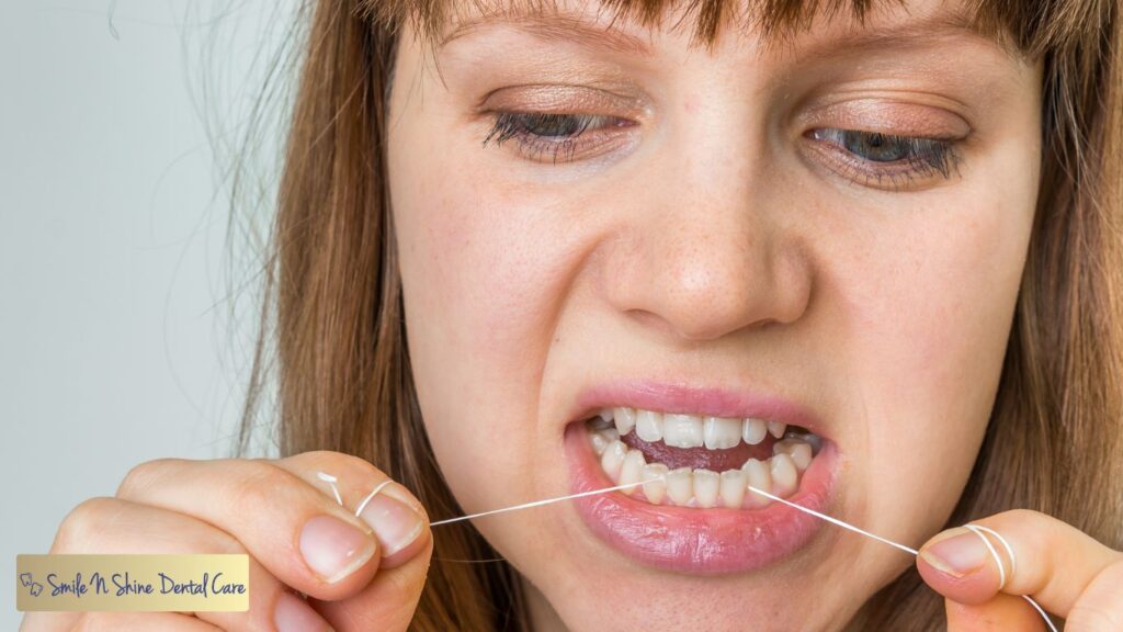 A female Flossing her teeth with Pain